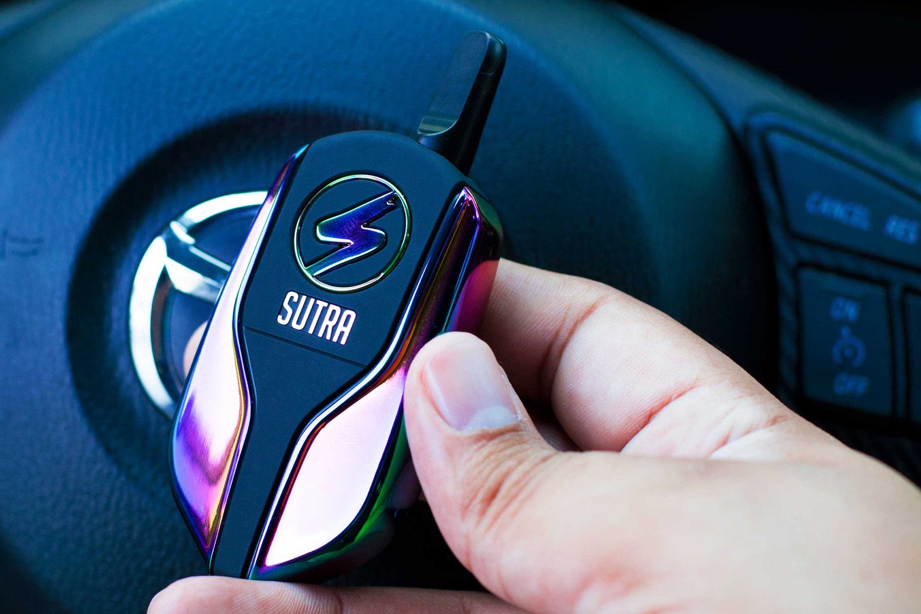 Man holding the Sutra Squeeze inside car next to steering wheel